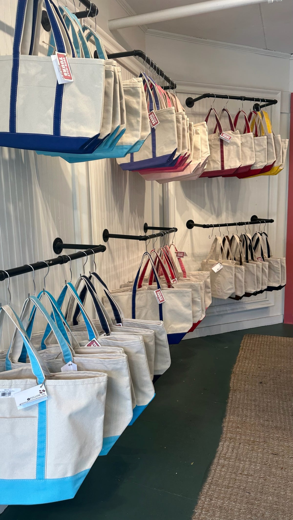 Colorful blank canvas boat totes on a wall rack